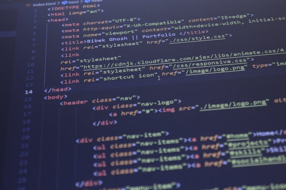 Close-up of a person's hand using a laptop on a wooden desk, with the screen displaying lines of code in various colors on a dark background. The person's wristwatch is visible, and the laptop feature